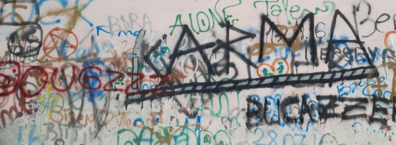 Duvar Üzerinde Sokak Grafitileri. Dağınık ve karışık grafiti yazılar. Belirgin KARMA yazısı.