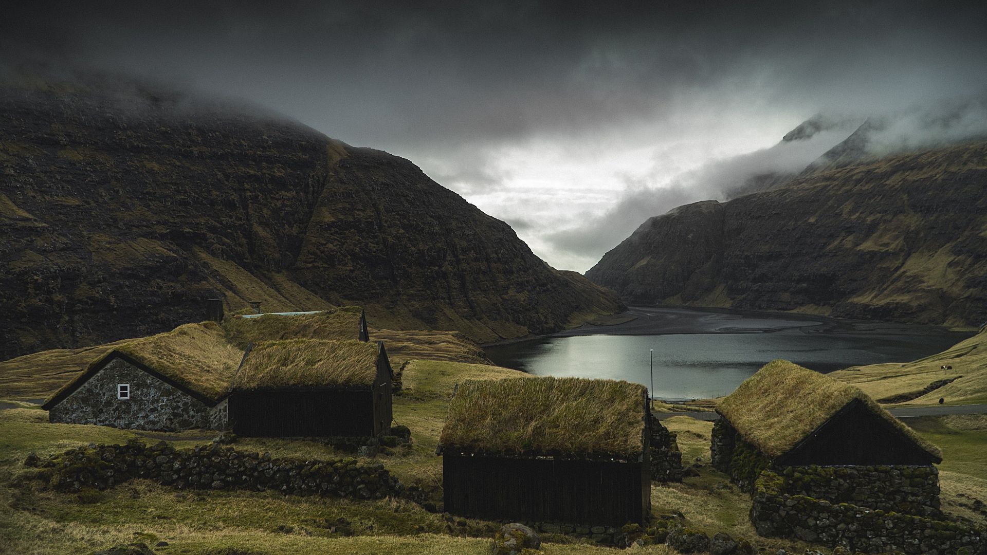 faroe-islands-lake-small-houses-dark-weather-clouds-field-landscape-41091.jpg