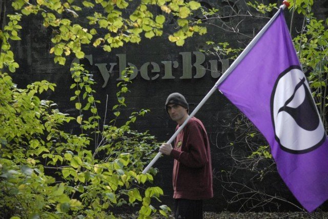 Sven Olaf Kamphuis, CyberBunkers karargahı önünde Pirate Party bayrağıyla birlikte.