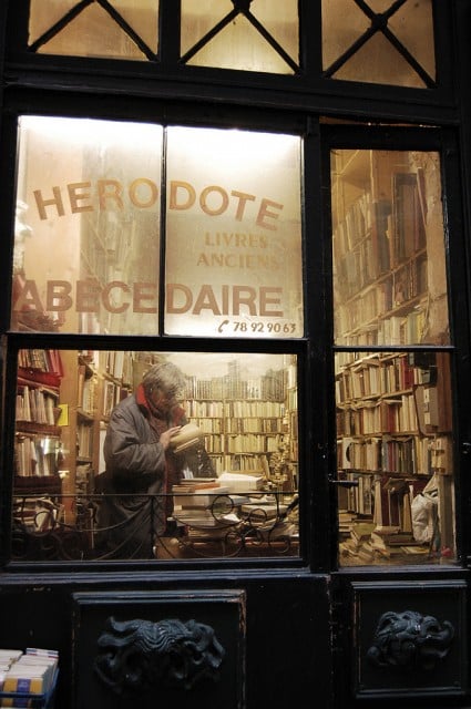 Fransa, Lyon'da buğulu camın ardından kitaplara bakarken sokakta yaşayan birinin restoran camından bakarken açlığını düşünün