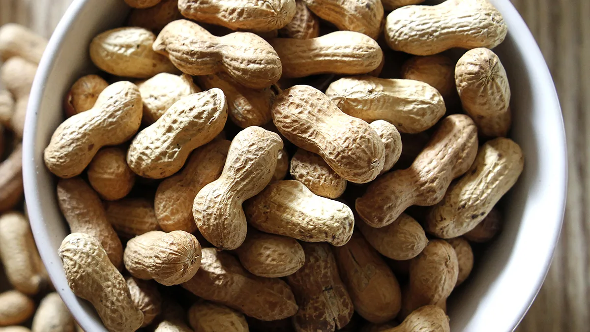 Bowl of peanuts on wooden table